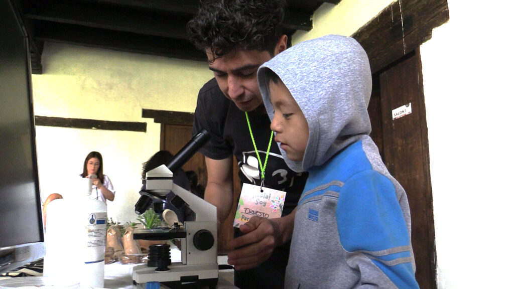 niño viendo a través de un microscopio